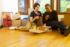 people sitting on floor eating pizza